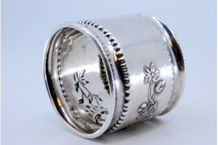 Argola de guardanapo em prata com motivos florais relevados.
